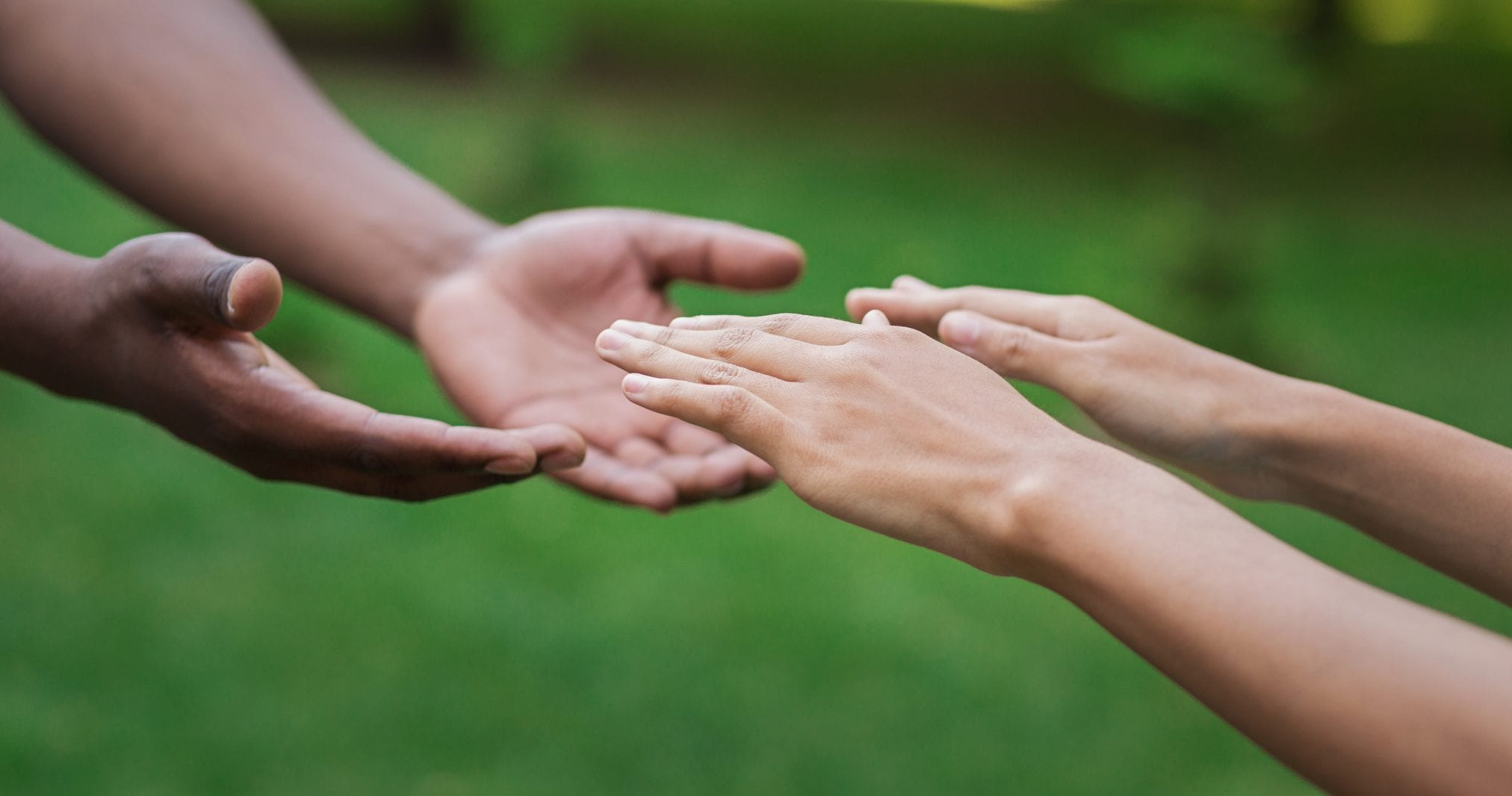 Diverse male and female hands stretch to each other